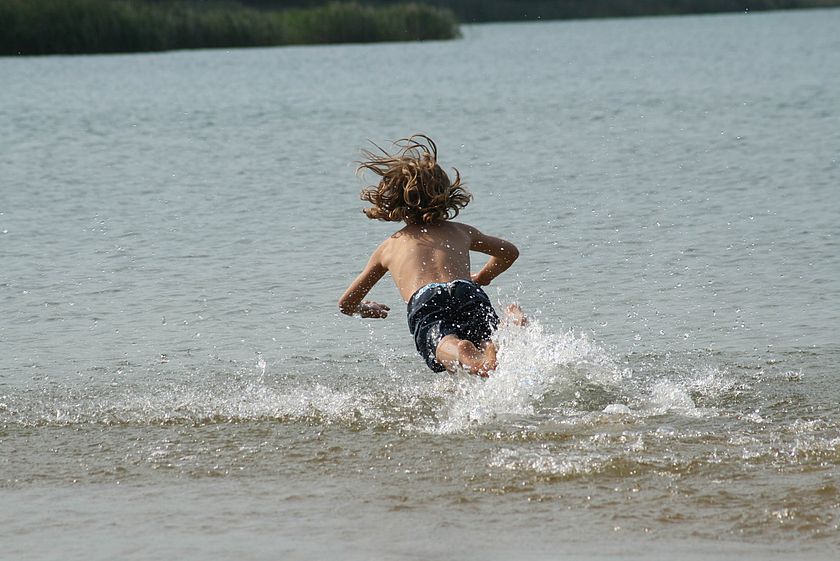 Junge springt im Wasser am Grünewalder Lauch