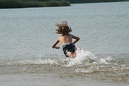 Junge springt im Wasser am Grünewalder Lauch